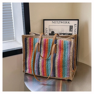 Detail of colorful striped woven straw tote bag with brown faux leather handles