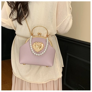 Detail of lavender beaded handbag with embossed gold heart and pearl strap decoration