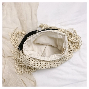 Detail of bohemian ivory crochet tote with leather handle and fringe tassel trim