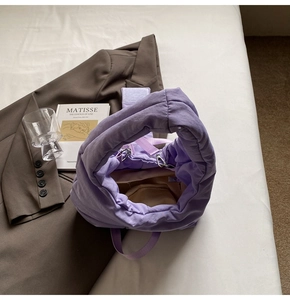 Detail of purple quilted nylon tote bag with plush cloud texture and thick handles