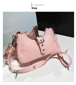 Détail du sac bandoulière en cuir verni rose avec clous argentés et boucle métallique