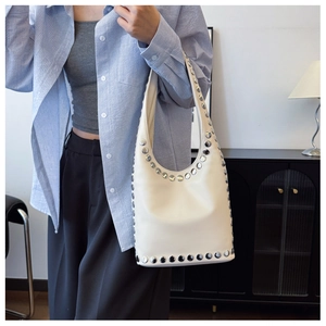 Detailansicht der beigen Hobo-Tasche mit silbernen Nieten und glattem Kunstleder