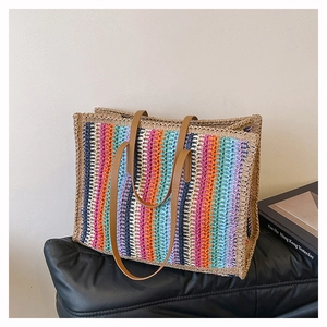 Detailed view of colorful striped woven tote bag with premium brown leather shoulder straps
