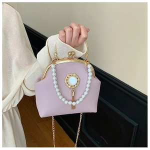 Detailed shot of lilac lychee leather handbag with pearl chain and metallic tassel decor