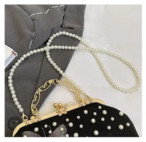Détails du sac de soirée noir avec ornements en perles et fermoir papillon doré élégant