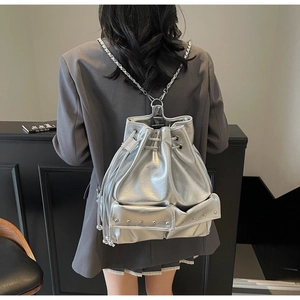 Close-up of shiny silver backpack with metallic chain straps and rivet details