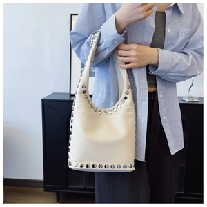 Detail der silbernen Nieten an der cremeweißen Hobo-Tasche, am Model präsentiert