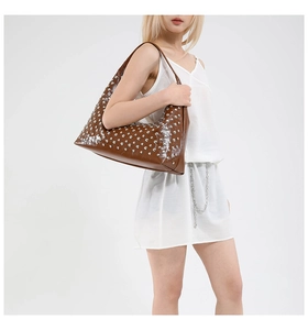 Detail of dark brown hobo bag with silver studs and polished faux leather texture