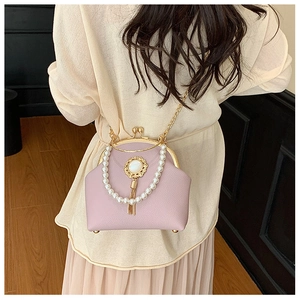 Detail of lilac leather shell bag with pearl handle and sunflower tassel charm