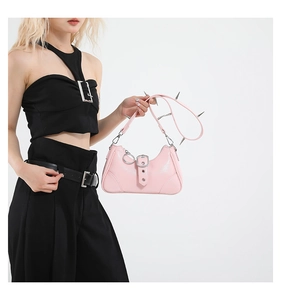 Détail du sac punk en cuir verni rose avec rivets argentés sur la bandoulière