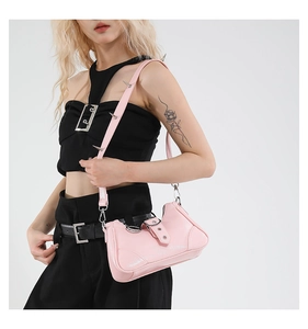 Détail d'un sac sous les aisselles en cuir verni rose avec des pointes métalliques