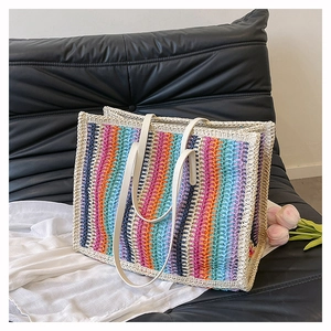 Detail of colorful rainbow striped straw tote bag with durable white faux leather handles