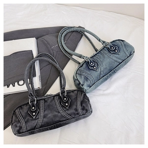 Detail of vintage washed denim barrel bags in blue and black with rivet accents
