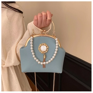 Detail of light blue lychee texture bag with gold metal clasp and pearl handle