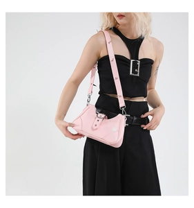 Détail du sac Y2K en cuir verni rose avec clous métalliques sur la bandoulière