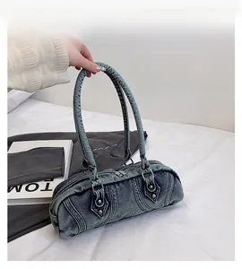 Detail of vintage washed denim handbag with reinforced stitching and metal rivets