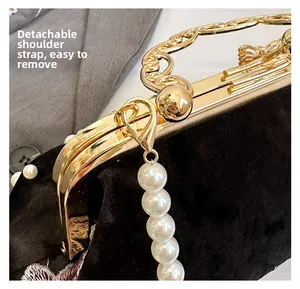 Détail de la bandoulière en perles amovible et poignée dorée sur le sac de soirée velours