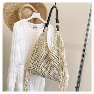 Detail of handmade cream crochet tote with side fringes and black leather shoulder strap
