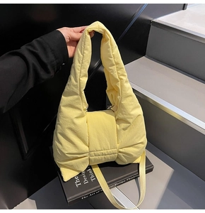 Detail of light yellow quilted nylon bow handbag with detachable shoulder strap