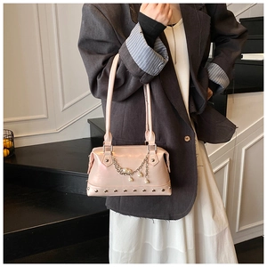 Detail der rosa Lackleder-Handtasche mit Perlenfransen und Metallnieten-Verzierung