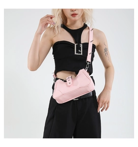 Vue détaillée du sac punk rose avec des clous métalliques et des pointes argentées sur la bandoulière