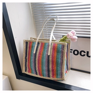 Detail of colorful woven straw tote bag with vibrant rainbow stripes and soft sunlight