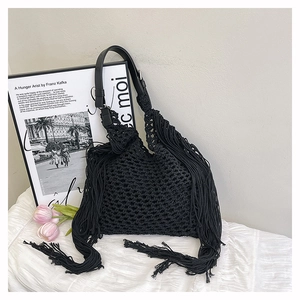 Detailed close-up of a black crochet woven bag with long tassels and mesh texture