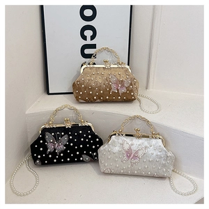 Détails des pochettes en velours avec chaînes de perles et broderie papillon