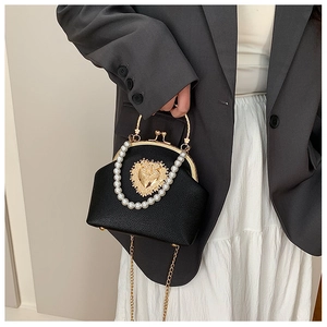 Detail of beaded handle and golden heart metal clasp on black textured shell bag