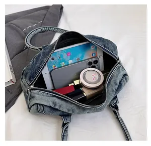 Detail of spacious interior storage in light blue washed denim bag with smooth zipper