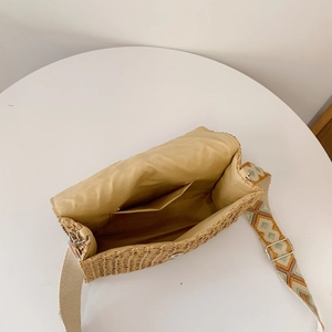 Straw woven crossbody bag with ethnic wide strap and spacious interior for summer travel