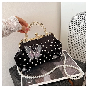Détail du sac coquillage en velours avec perles, broderie papillon et anse dorée