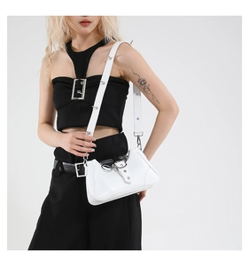 Détail du sac blanc en cuir grainé avec clous argentés et boucles sur la sangle