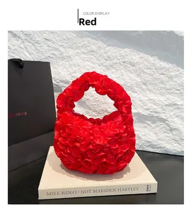 Detail view of red pleated petal bag with satin ruffle texture on white books