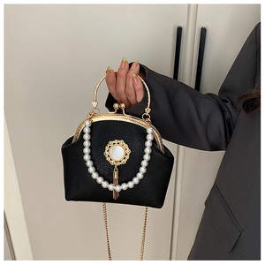 Detail of black pebbled leather evening bag with pearl chain and golden fringe