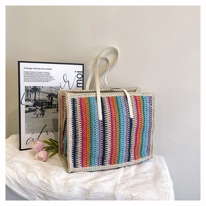 Detail of colorful rainbow striped woven tote bag with durable white leather handles