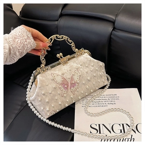 Détail du sac de soirée vintage en velours avec broderie papillon et perles élégantes