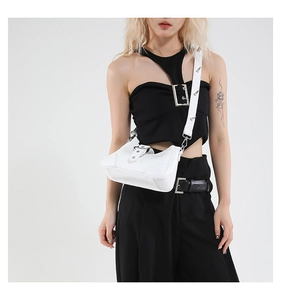 Gros plan du sac blanc en cuir verni avec des clous en métal argenté de style punk rock
