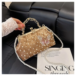 Détail du sac coquille en velours avec perles, broderies fleurs et anse dorée