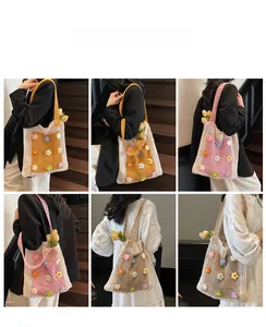 Détail des sacs cabas en maille crochetée à fleurs colorées portés par un mannequin