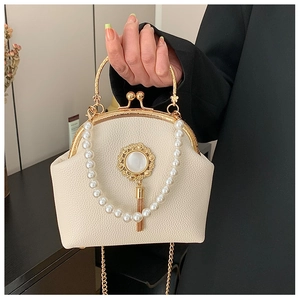 Detail of beaded evening bag featuring cream lychee leather and pearl tassel charm