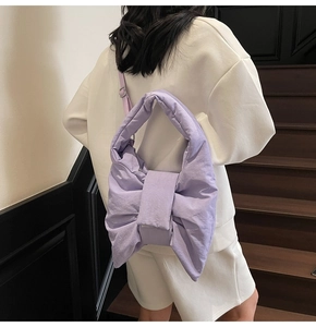 Detail view of large lavender puff bow shoulder bag showing texture and adjustable strap