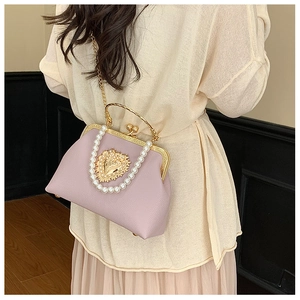 Detail of light purple leather bag with pearl heart embellishment and metal handle