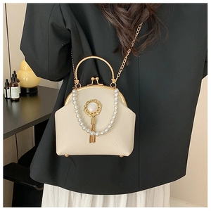 Detail of beaded shell bag with kiss-lock closure, gold handle, and pearl fringe tassels