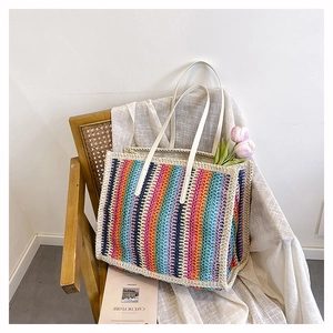 Detail of colorful rainbow striped crochet tote bag with long cream shoulder straps