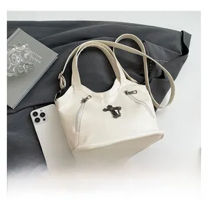 Detail of white cross tote bag with phone and book showing large capacity scale