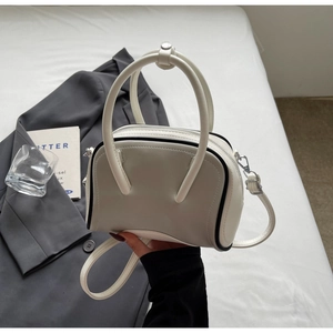 Detail of white bowling bag with black contrast piping and adjustable shoulder strap