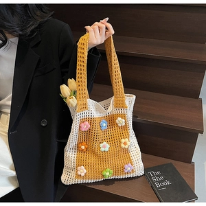 Détail d'un sac cabas au crochet avec des fleurs 3D colorées et une maille ajourée
