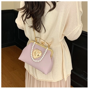 Detail of lavender frame bag featuring pearl handle and golden heart relief charm