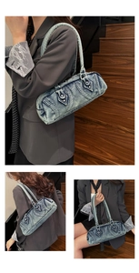 Detail of retro washed denim Boston bag featuring metal rivets and contrast stitching